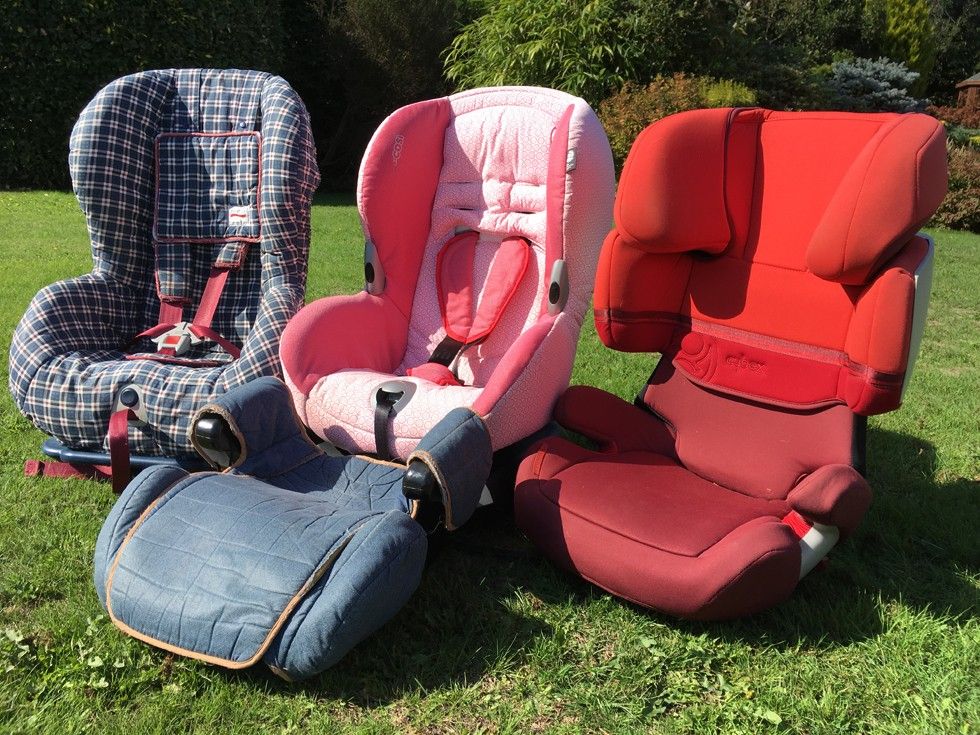 Three child and booster seats on a lawn